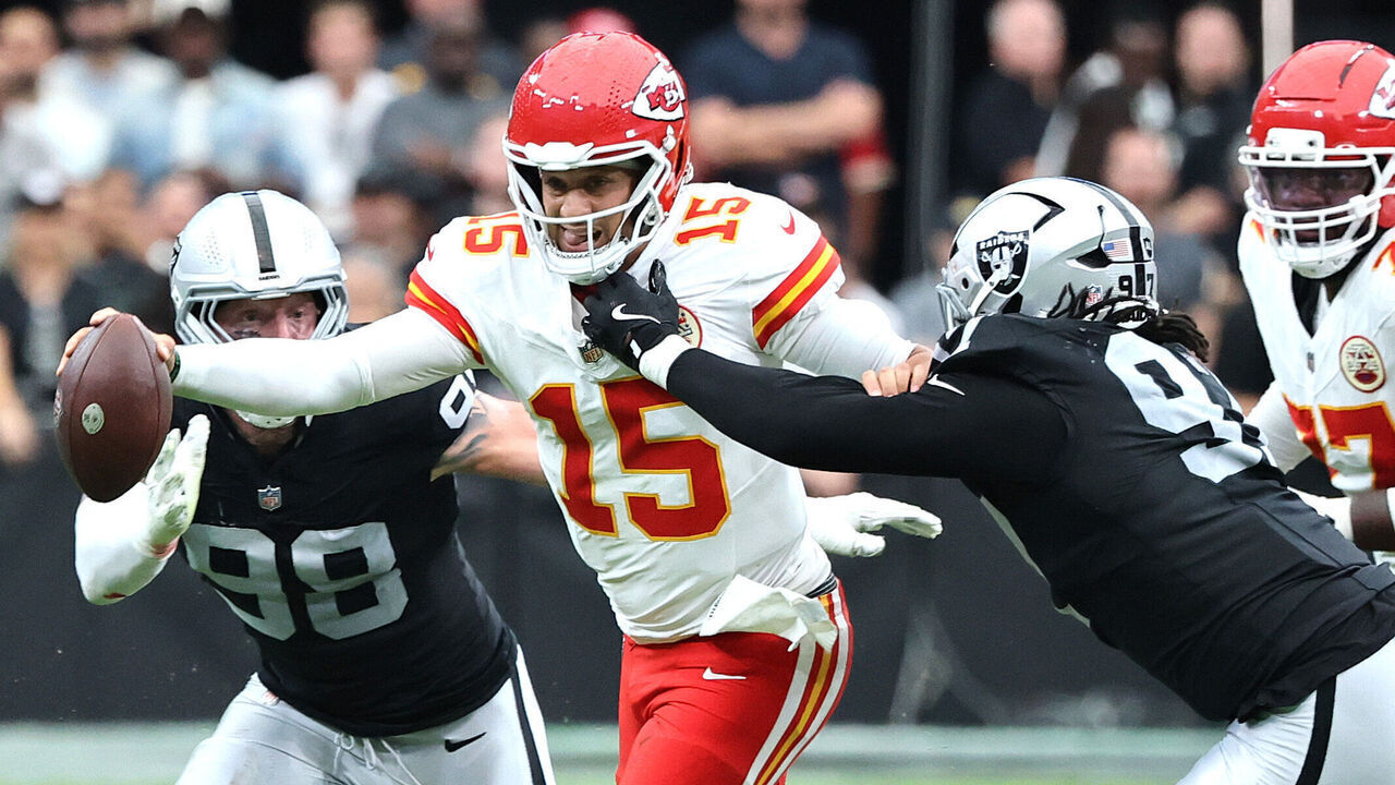 LAS VEGAS, NEVADA - OCTOBER 04: Patrick Mahomes #15 of the Kansas City Chiefs scrambles with the ball while under pressure from Tonka Hemingway #97 of the Las Vegas Raiders and Maxx Crosby #98 during the second quarter at Allegiant Stadium on October 04, 2026 in Las Vegas, Nevada.
