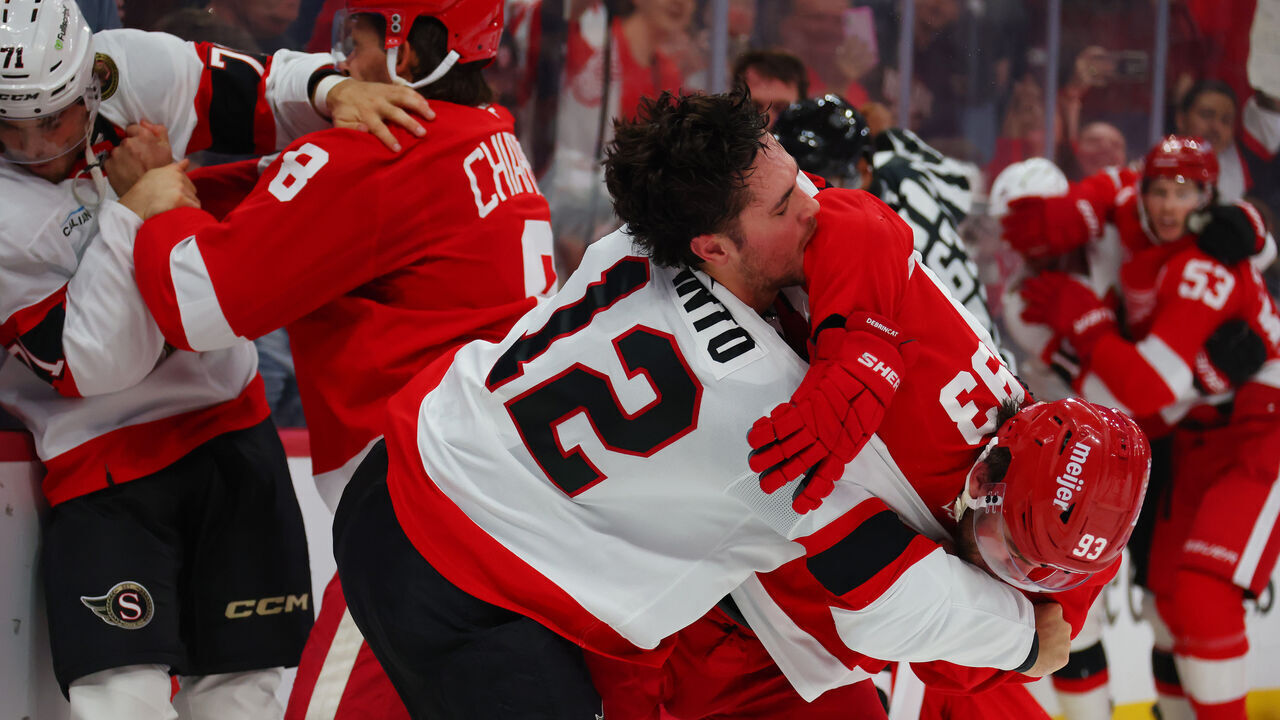 DETROIT, MICHIGAN - OCTOBER 06: Alex DeBrincat #93 of the Detroit Red Wings and Shane Pinto #12 of the Ottawa Senators fight at the end of the second period at Little Caesars Arena on October 06, 2026 in Detroit, Michigan.
