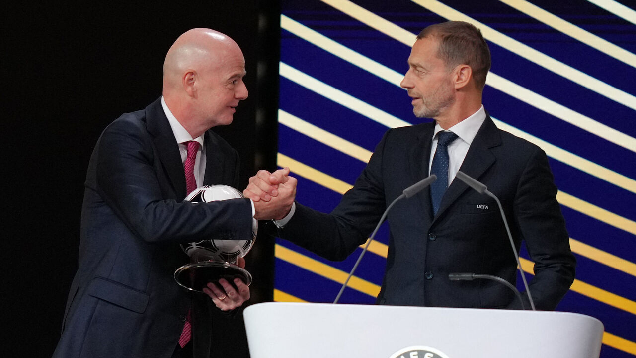 TOPSHOT - FIFA President Gianni Infantino (L) embraces UEFA president Aleksander Ceferin after addressing the 50th UEFA Ordinary Congress in Brussels on February 12, 2026.