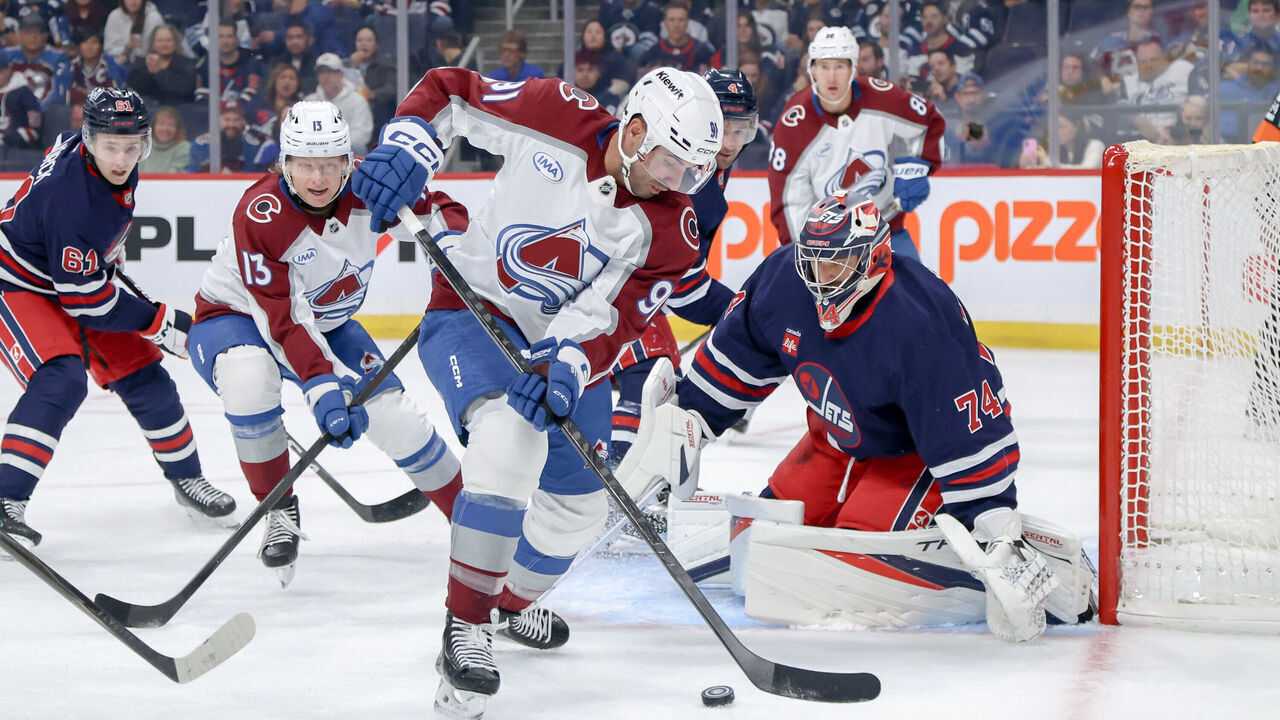 WINNIPEG, CANADA - OCTOBER 7: Nazem Kadri #91 of the Colorado Avalanche takes the puck to the net as goaltender Stuart Skinner #74 of the Winnipeg Jets guards the goal during first period action at the Canada Life Centre on October 7, 2026 in Winnipeg, Manitoba, Canada.