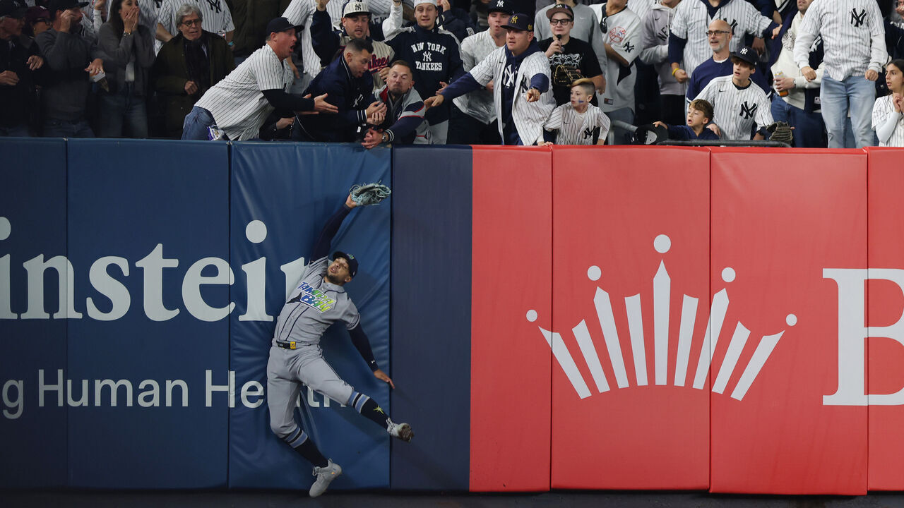 NEW YORK, NEW YORK - OCTOBER 07: Victor Mesa Jr. #25 of the Tampa Bay Rays is unable to make a catch as fans interfere on a ball hit by Anthony Volpe #11 of the New York Yankees during the sixth inning in game three of the American League Division Series at Yankee Stadium on October 07, 2026 in the Bronx borough of New York City.