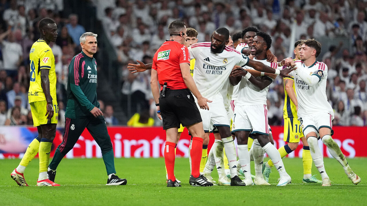 MADRID, SPAIN - OCTOBER 10: Vinicius Junior of Real Madrid is held back by teammate Antonio Rudiger after receiving a red card from referee Isidro Diaz de Mera Escuderos during the LaLiga EA Sports 2026/27 match between Real Madrid and Villarreal CF at Estadio Santiago Bernabeu on October 10, 2026 in Madrid, Spain.