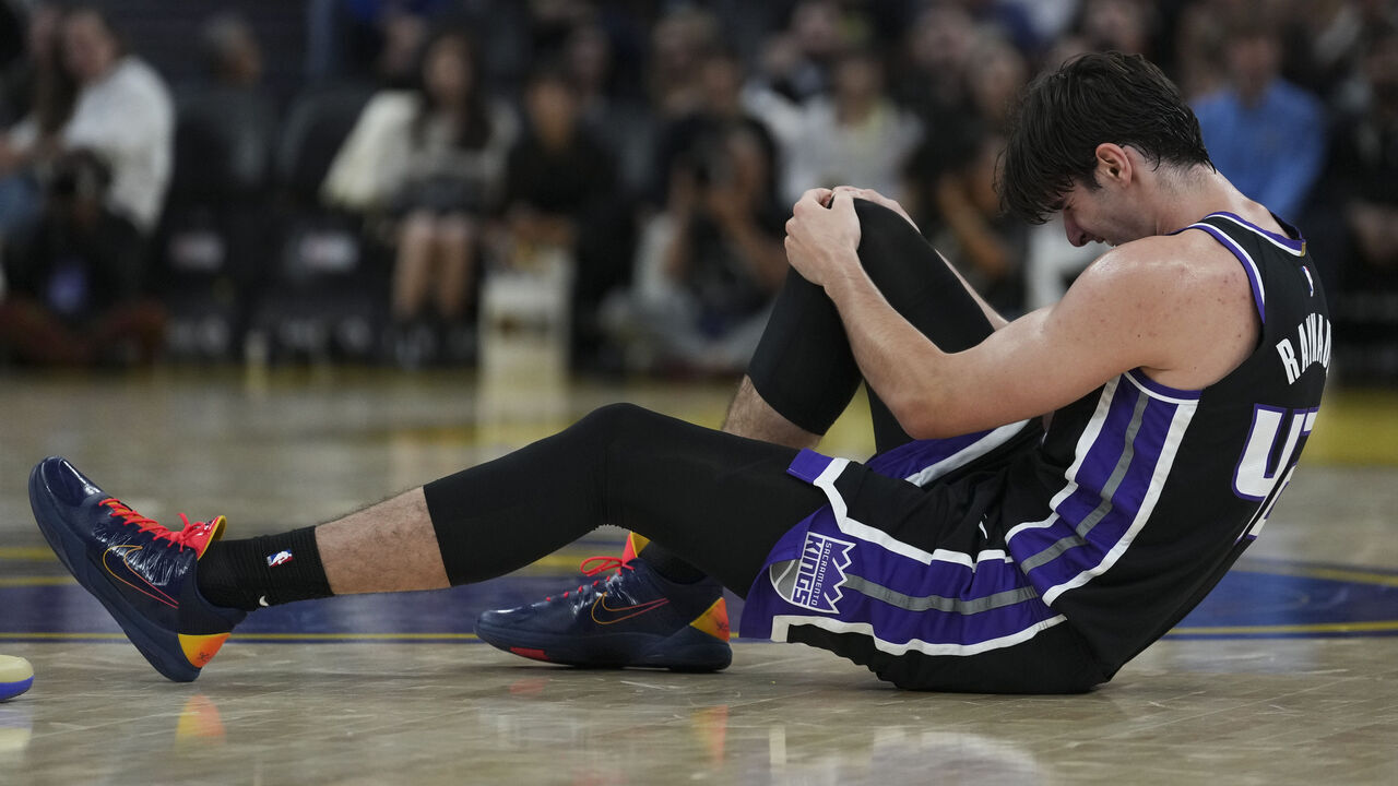 SAN FRANCISCO, CALIFORNIA - OCTOBER 10: Maxime Raynaud #42 of the Sacramento Kings grabs his knee after an injury during the first half of the preseason game against the Golden State Warriors at Chase Center on October 10, 2026 in San Francisco, California.