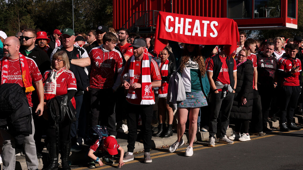 LIVERPOOL, ENGLAND - OCTOBER 11: A Liverpool fan holds up a scarf that reads "Cheats" aimed towards the Manchester City team bus before the Premier League 2026/27 match between Liverpool FC and Manchester City at Anfield on October 11, 2026 in Liverpool, England.