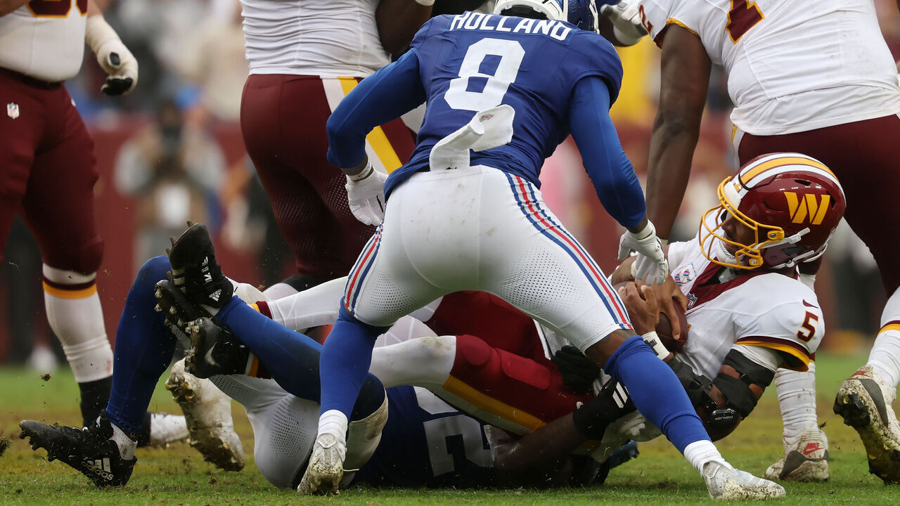LANDOVER, MARYLAND - OCTOBER 11: Jayden Daniels #5 of the Washington Commanders is tackled during the fourth quarter of the game against the New York Giants at Northwest Stadium on October 11, 2026 in Landover, Maryland.