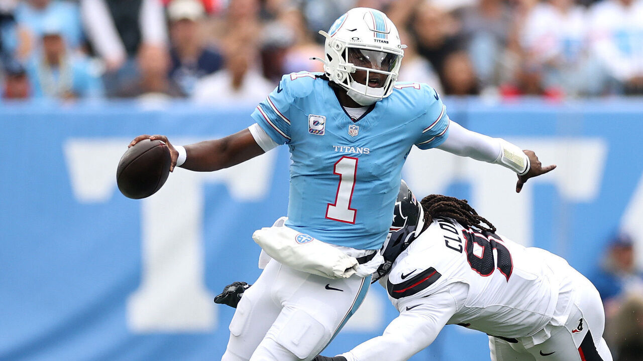 NASHVILLE, TENNESSEE - OCTOBER 11: Cam Ward #1 of the Tennessee Titans looks to pass while under pressure from Jadeveon Clowney #90 of the Houston Texans during the third quarter of the game at Nissan Stadium on October 11, 2026 in Nashville, Tennessee.