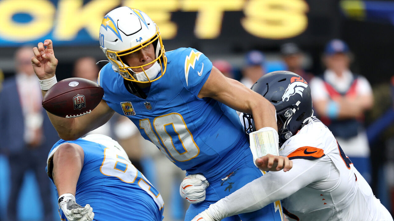 INGLEWOOD, CALIFORNIA - OCTOBER 11: Justin Herbert #10 of the Los Angeles Chargers fumbles the ball after a tackle by D.J. Jones #93 of the Denver Broncos during the fourth quarter of the game at SoFi Stadium on October 11, 2026 in Inglewood, California.