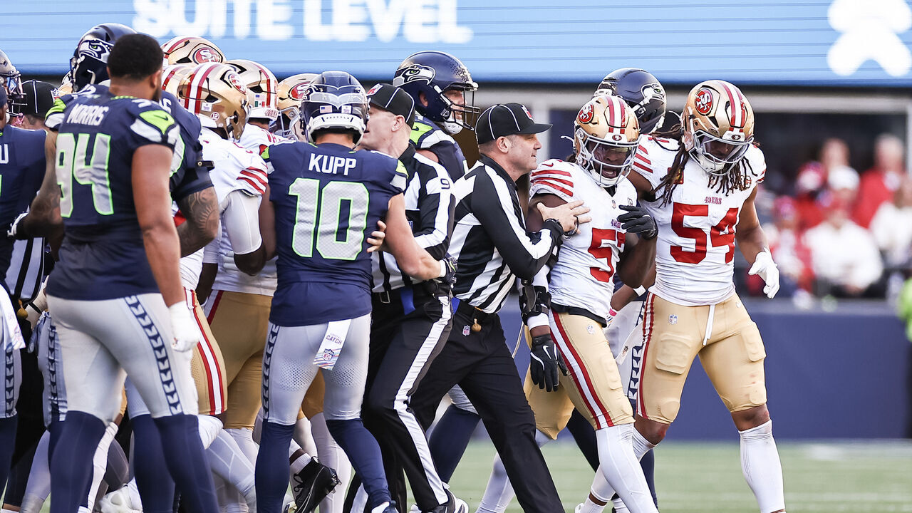 SEATTLE, WASHINGTON - OCTOBER 11: Dre Greenlaw #57 of the San Francisco 49ers is escorted away from the Seattle Seahawks sideline after a late hit on Sam Darnold #14 of the Seattle Seahawks (not pictured) during the second quarter at Lumen Field on October 11, 2026 in Seattle, Washington.