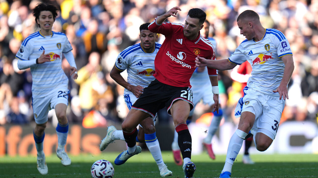 Manchester United's Diogo Dalot (centre) battles for the ball with Leeds United players during the Premier League match at Elland Road, Leeds. Picture date: Sunday October 18, 2026.