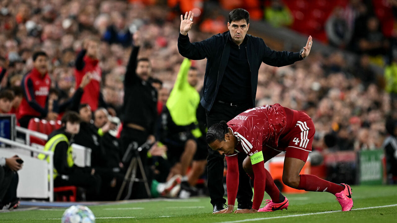 Liverpool's Dutch defender #04 Virgil van Dijk falls in front of Liverpool's Spanish head coach Andoni Iraola during the UEFA Champions League football match between Liverpool and Atletico Madrid at Anfield in Liverpool, north west England on September 9, 2026.