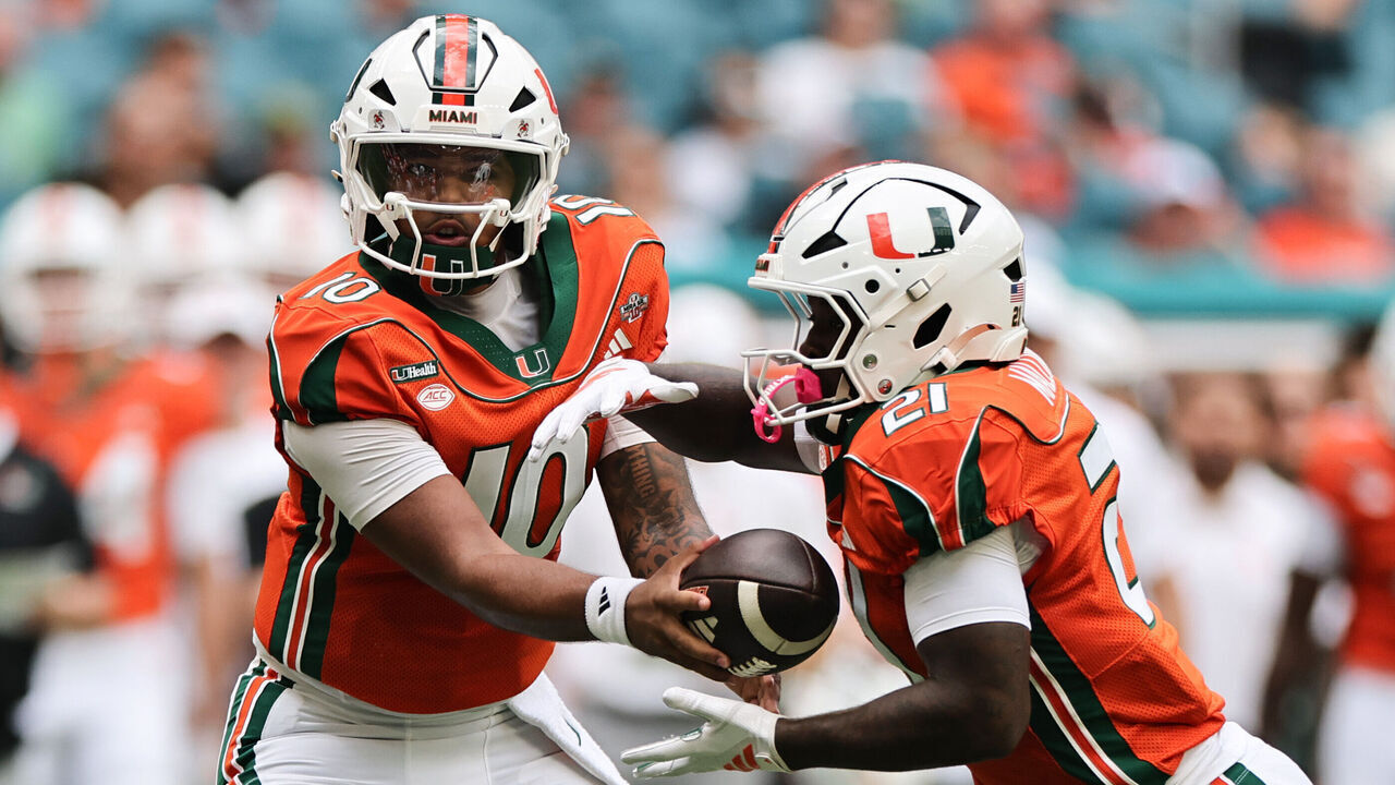 MIAMI GARDENS, FLORIDA - OCTOBER 24: Darian Mensah #10 of the Miami Hurricanes hands off to Javian Mallory #21 of the Miami Hurricanes against the Pittsburgh Panthers during the second half at Hard Rock Stadium on October 24, 2026 in Miami Gardens, Florida.