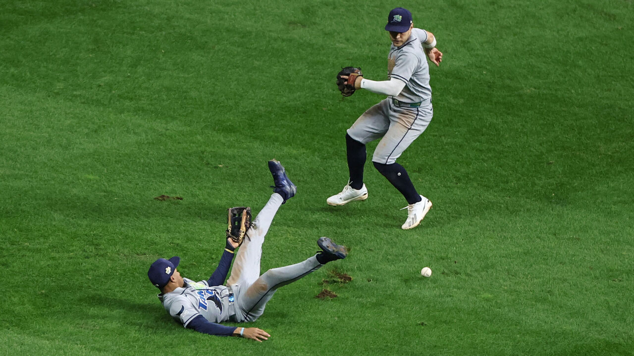 MILWAUKEE, WI - OCTOBER 24: Chandler Simpson #14 of the Tampa Bay Rays deflects a fly ball hit by Christian Yelich #22 of the Milwaukee Brewers as Taylor Walls #6 looks on in the sixth inning during Game Two of the 2026 World Series presented by Capital One between the Tampa Bay Rays and the Milwaukee Brewers at American Family Field on Saturday, October 24, 2026 in Milwaukee, Wisconsin.