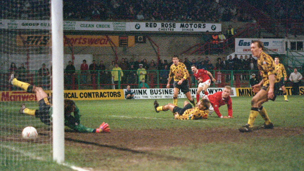 WREXHAM, UNITED KINGDOM - JANUARY 04: Wrexham striker Steve Watkin (2nd r) scores the winning goal past David Seaman watched by left to right, David O' Leary, Tony Adams (floor) Gordon Davies and Lee Dixon during the FA Cup 3rd round match between Fourth Division Wrexham and Arsenal at the Racecourse Ground on January 4, 1992 in Wrexham, Wales.