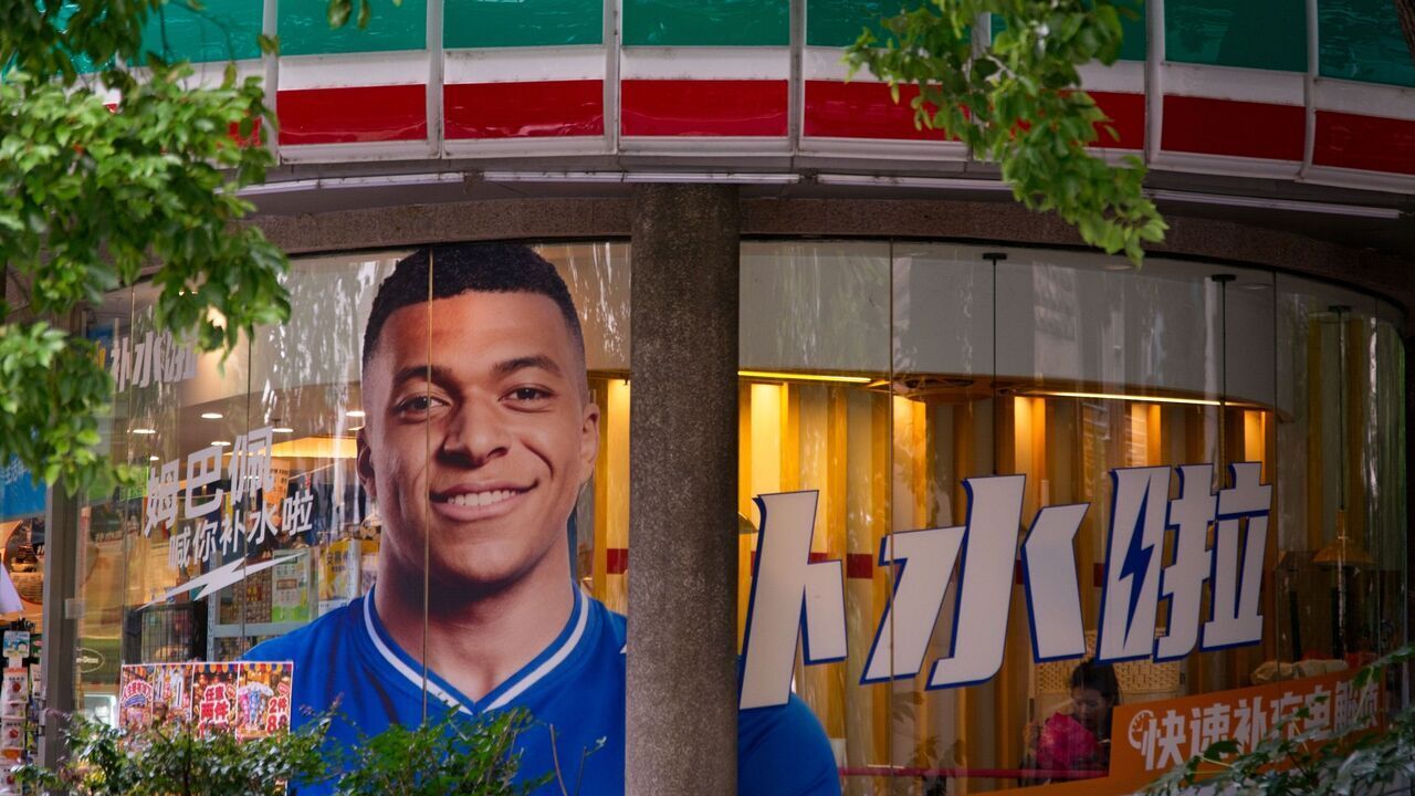 An advertisement featuring Kylian Mbappe for a drink brand is displayed in a convenience store in Shanghai, China, on October 27, 2026.