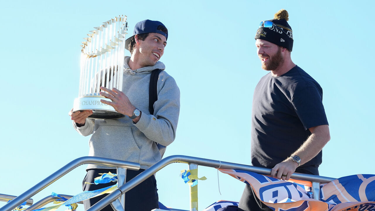 MILWAUKEE, WISCONSIN - OCTOBER 29: Christian Yelich #22 and Brandon Woodruff #53 of the Milwaukee Brewers get off the plane holding the 2026 World Series Trophy on October 29, 2026 in Milwaukee, Wisconsin.