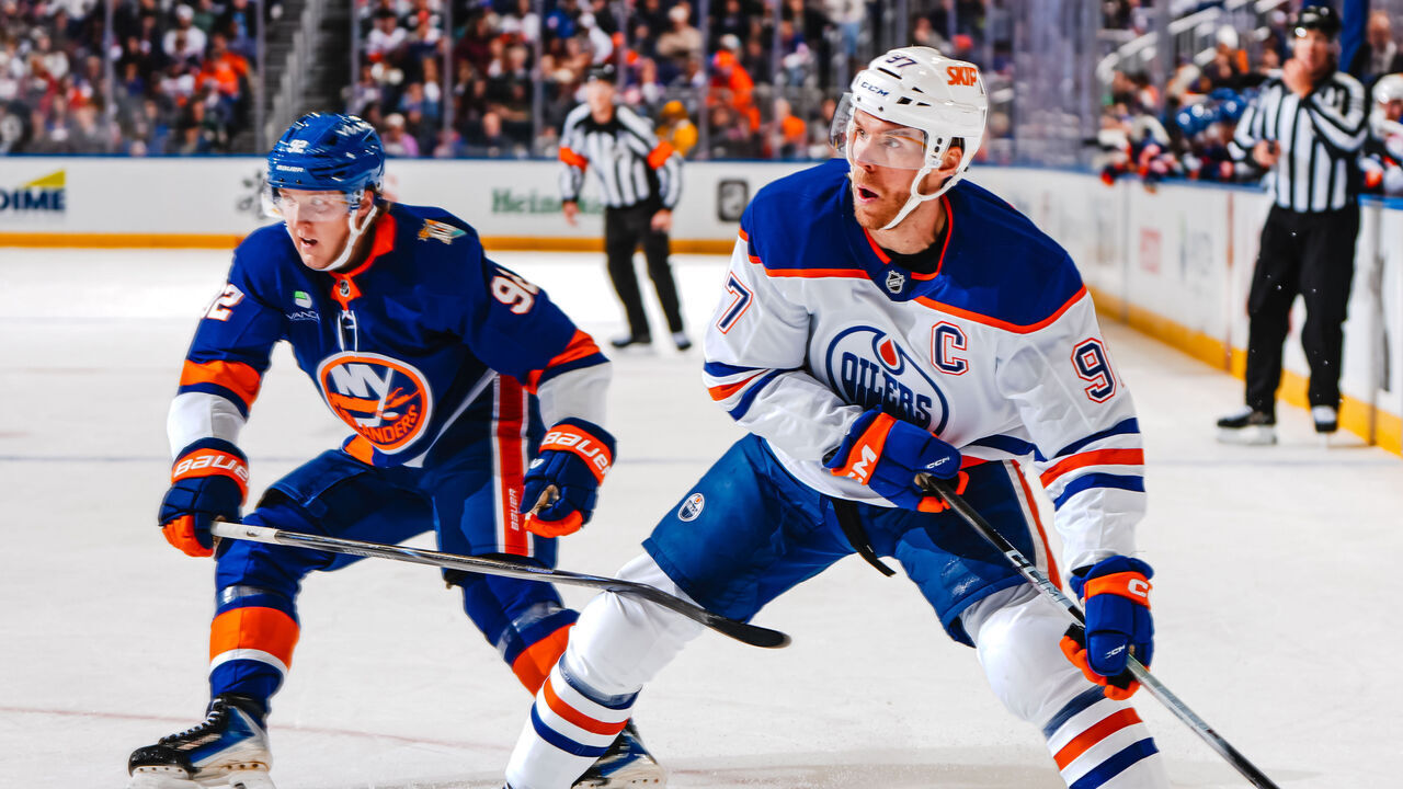 ELMONT, NEW YORK - OCTOBER 31: Connor McDavid #97 of the Edmonton Oilers handles the puck as Simon Holmstrom #92 of the New York Islanders defends during the second period at UBS Arena on October 31, 2026 in Elmont, New York.